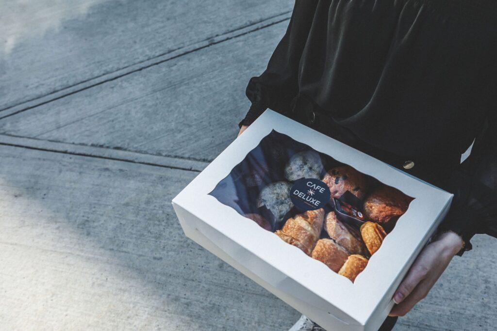 A customer taking home a box of treats for their Catering Ottawa order