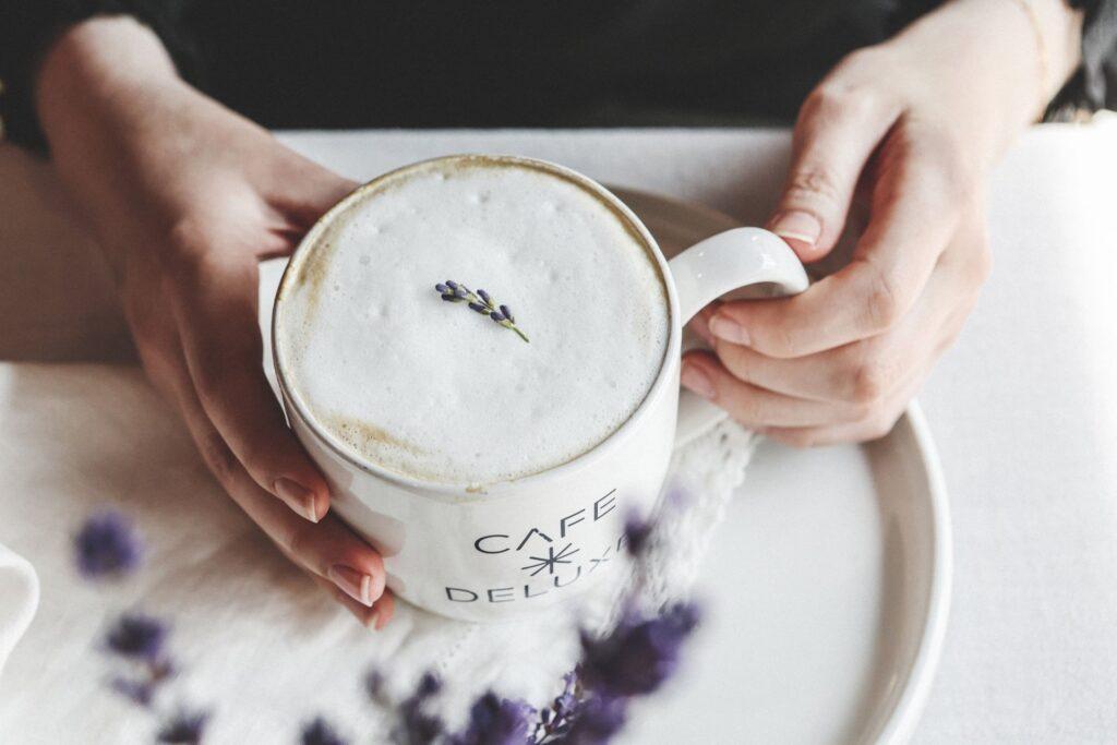 A customer holding a cappuccino, waiting for their Catering Ottawa order